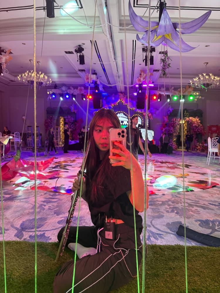 Monica taking a mirror photo at a colourful event