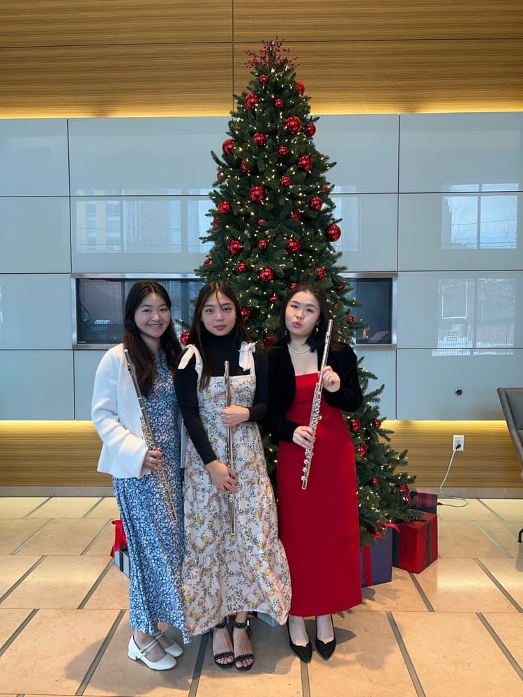 Monica and two friends beside a Christmas tree